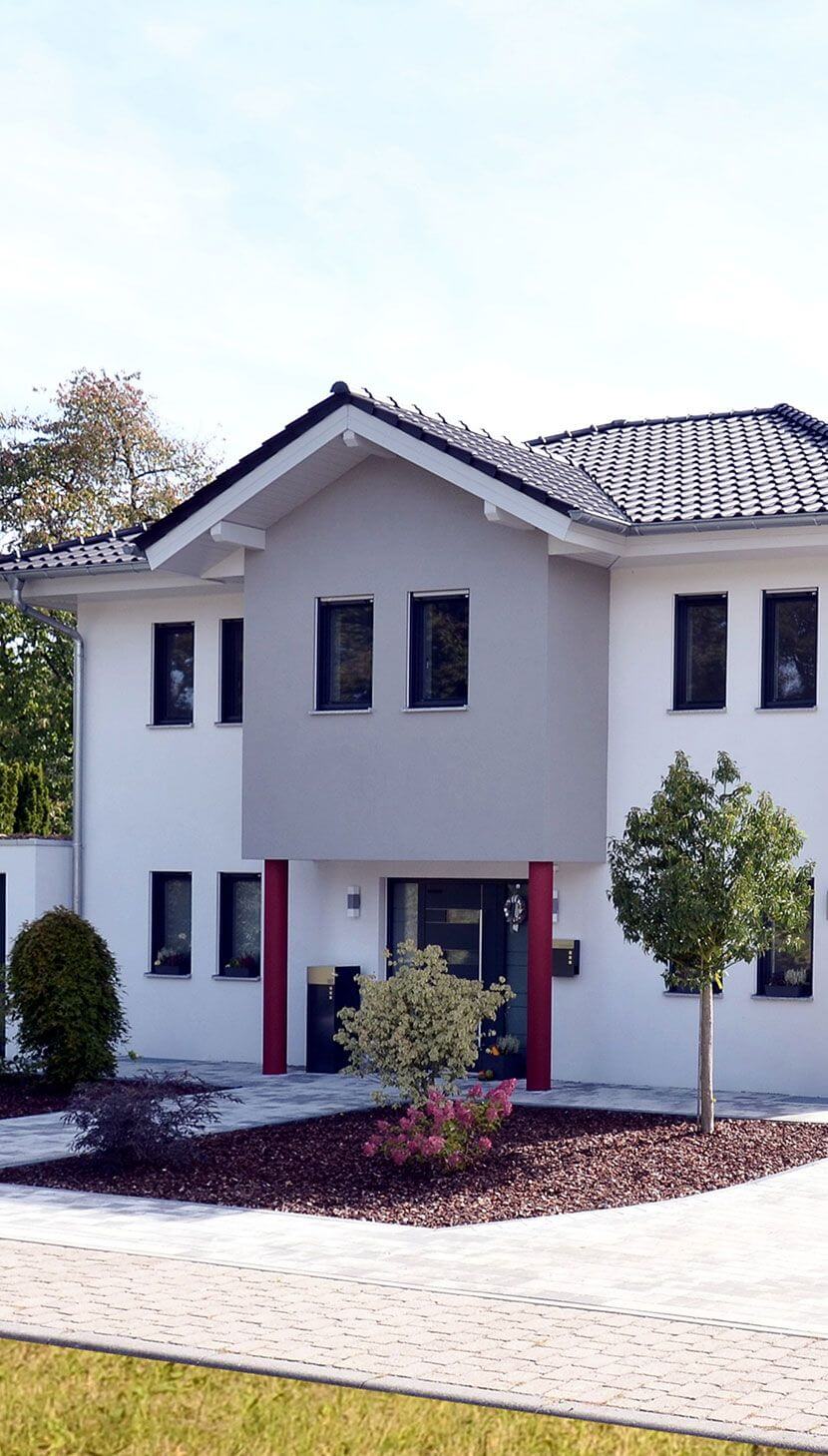 Weißes, modernes Haus mit roten Säulen - zeigt Eingangsbereich und Weg