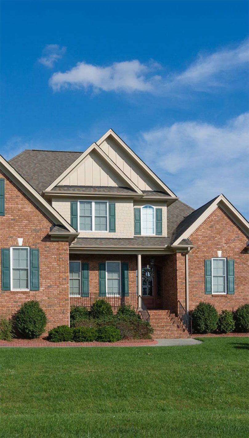 Haus aus Ziegelsteinen mit einer Wiese