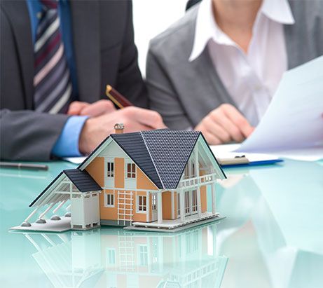 Kleines Haus auf einem Tisch und Markler im Hintergrund