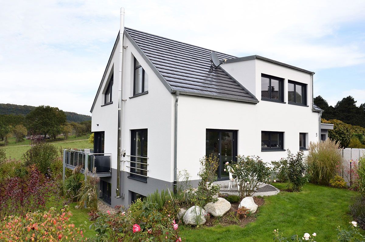 Weißes Haus mit Garten und blauem Himmel